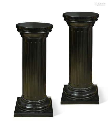 A pair of ebonised fluted column pedestals,