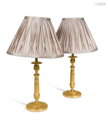 A pair of Regency engine turned ormolu candlestick lamps, ci...