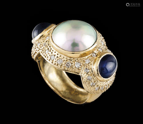 A ring Gold Set with one Mabe pearl flanked by 2 cabochon cu...