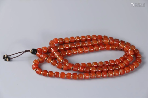 A STRING OF RED AGATE BARREL SHAPED BUDDHA BEADS