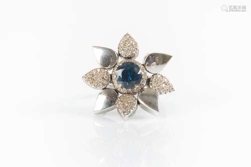 Bague fleur en or gris sertie d'une pierre bleue, les pétale...