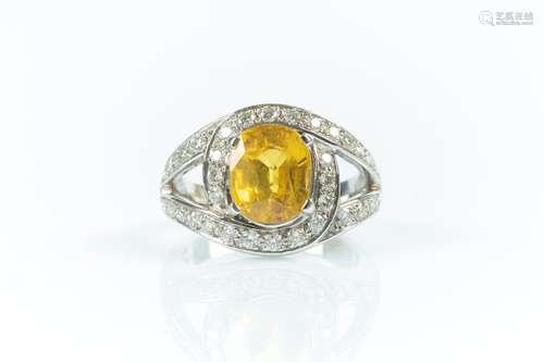 Bague en or gris sertie d'un saphir jaune ovale traité pesan...