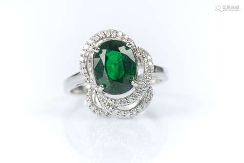 Bague en or gris sertie d'un grenat tsavorite ovale pesant e...