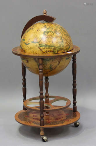 A late 20th century drinks globe with hinged lid, raised on ...