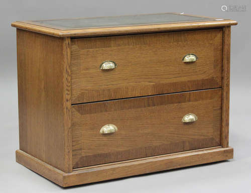 A modern oak filing chest, the top inset with gilt-tooled gr...