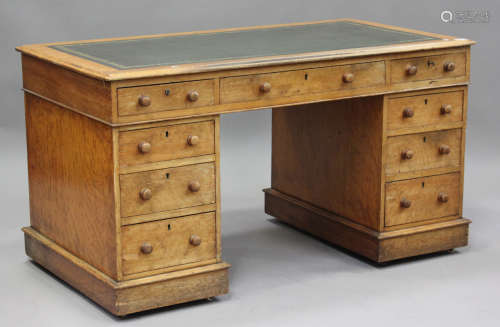 A late Victorian pale oak twin pedestal desk, the top inset ...