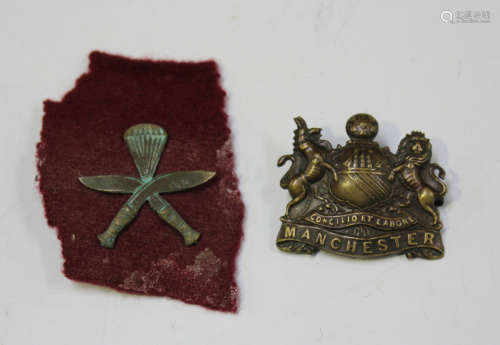 A Manchester Regiment bronze finish cap badge and a post-Sec...