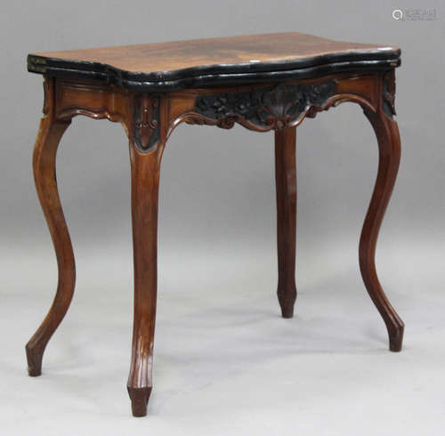 A mid-Victorian walnut fold-over card table with carved deco...