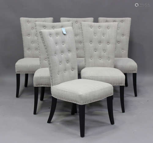 A set of six modern dining chairs, each upholstered in light...