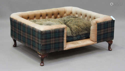 A modern buttoned brown leather and checked fabric dog's bed...