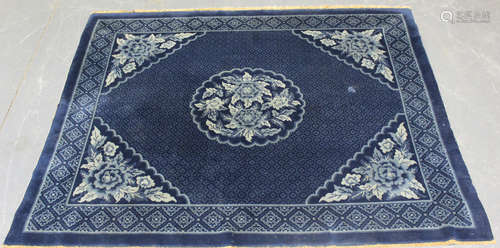 A Chinese rug, mid-20th century, the navy blue field with a ...