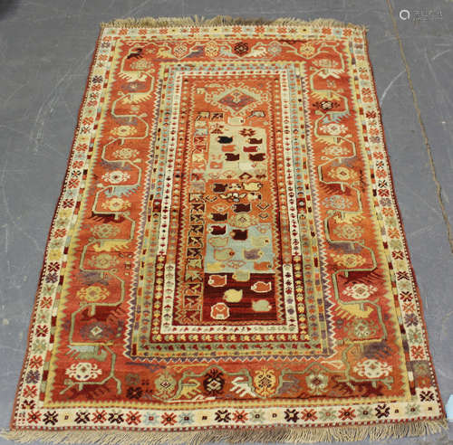 A Turkish rug, mid-20th century, the unusual terracotta fiel...