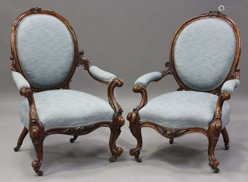 A near pair of mid-Victorian walnut showframe armchairs with...