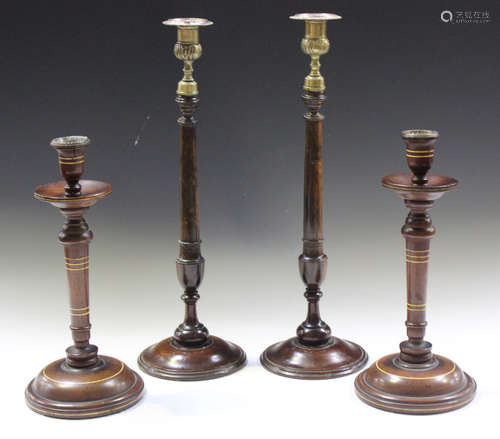 A pair of 19th century mahogany candlesticks with later fitt...