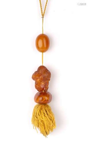 Amber and amber coloured pendants Chinese one in the form of...