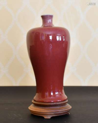 A CHINESE PINKY RED VASE AND STAND. 9ins high.