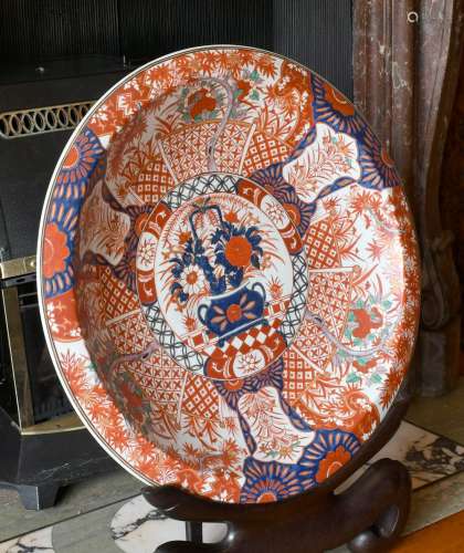 A LARGE JAPANESE IMARI DESIGN CIRCULAR CHARGER on a wooden s...