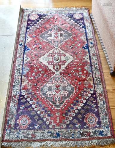 A PERSIAN WOOL RUG with three central medallions. 5ft 6ins x...