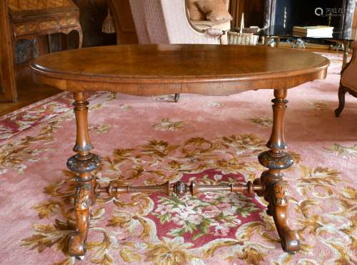 A VICTORIAN OVAL WALNUT STRETCHER TABLE with turned supports...