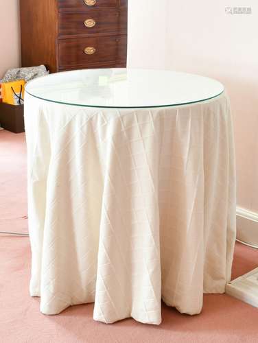 A GLASS TOP CIRCULAR TABLE with fabric cover, 2ft 4ins diame...