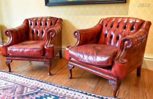 A MATCHING PAIR OF BUTTONED BACK ARMCHAIRS.