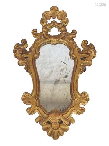 MIROIR de forme violonnée en bois doré à fronton coquille. I...