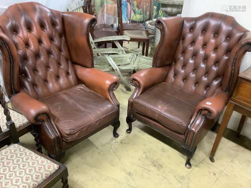 A pair of buttoned burgundy leather wing armchairs, width 86...