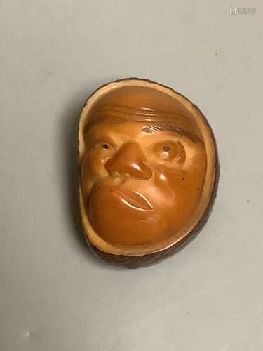 A Japanese carved nut mask netsuke