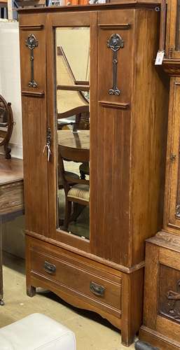 An early 20th century Arts & Crafts mirrored walnut wardrobe...