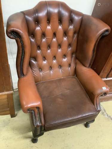 A buttoned burgundy leather wing armchair, width 86cm, depth...