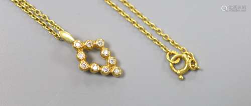 A modern 18ct gold and ten stone diamond chip set pendant, 1...