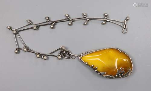 A stylish white metal and amber pebble set pendant necklace,...