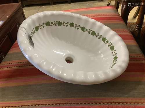 A ceramic shell sink with green ivy detail, width 52cm, dept...