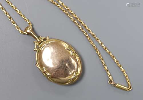 An Edwardian Art Nouveau 9ct gold oval locket, on a 9ct chai...