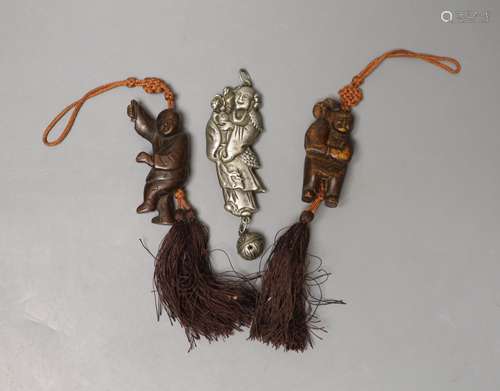 A Chinese metal baby's rattle and two carved wood figural pe...