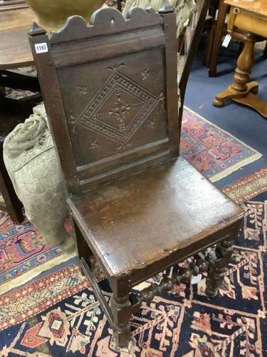 A 17th century oak back stool with lozenge carved decoration...