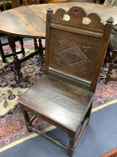 A 17th century oak back stool with lozenge carved decoration...