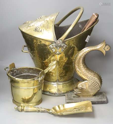 A brass coal bucket, a dolphin door porter, a scoop and a sm...