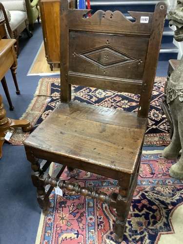 A 17th century oak back stool with lozenge carved decoration...