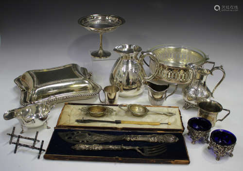 A group of plated items, including a pair of fish servers, c...
