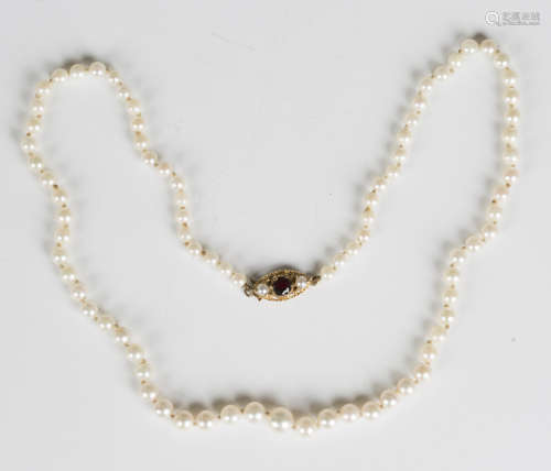 A single row necklace of graduated cultured pearls on a gold...