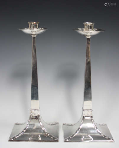 A pair of Arts and Crafts style silver candlesticks, each wi...
