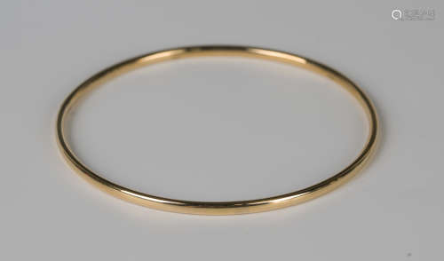 A gold circular bangle, detailed '18K', weight 7g, inside di...