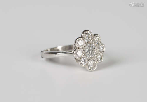 A platinum and diamond cluster ring, mounted with the princi...