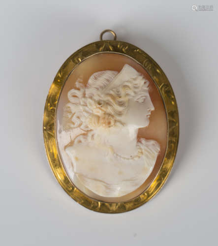 A gold mounted oval shell cameo pendant brooch, carved as a ...