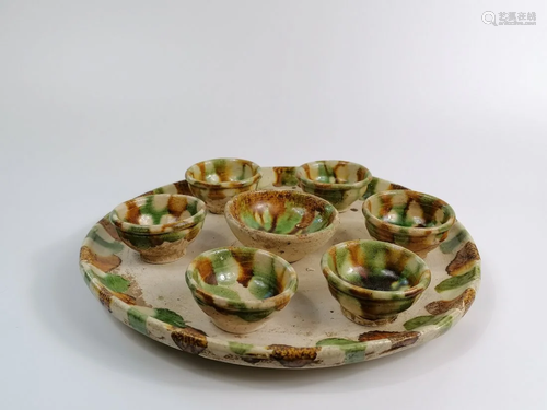 A SANCAI GLAZED POTTERY CIRCULAR TRAY AND SEVEN CUPS