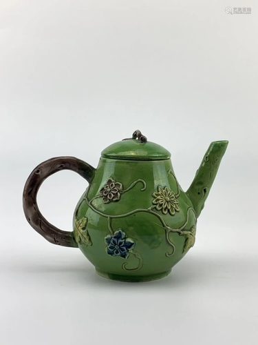 A CARVED AND MOLDED TEAPOT AND COVER