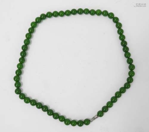 COLLIER de perles dures vertes sculptées. Long.: 46 cm.