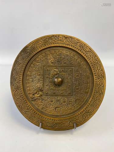 MIROIR ROND EN BRONZE Chine A patine dorée, il est décoré de...