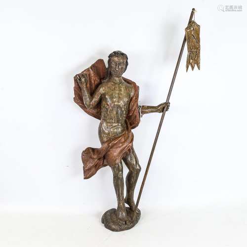 A carved and painted wood religious figure carrying a pennan...